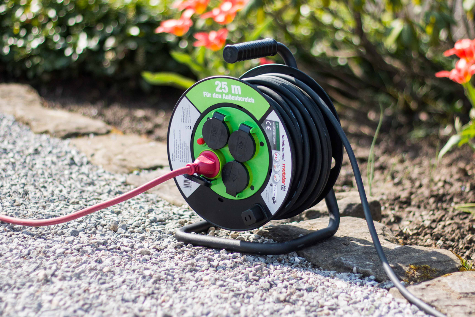 Cable drum 25 m is in the garden on a gravel path Cable drum 25 m is in the garden on a gravel path