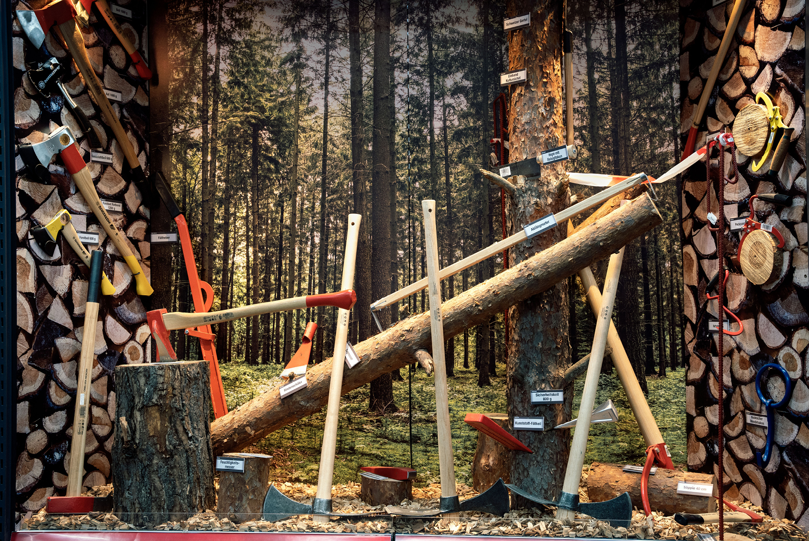 Presentation of axes and hatchets with rustic wooden trunks and forest background Presentation of axes and hatchets with rustic wooden trunks and forest background